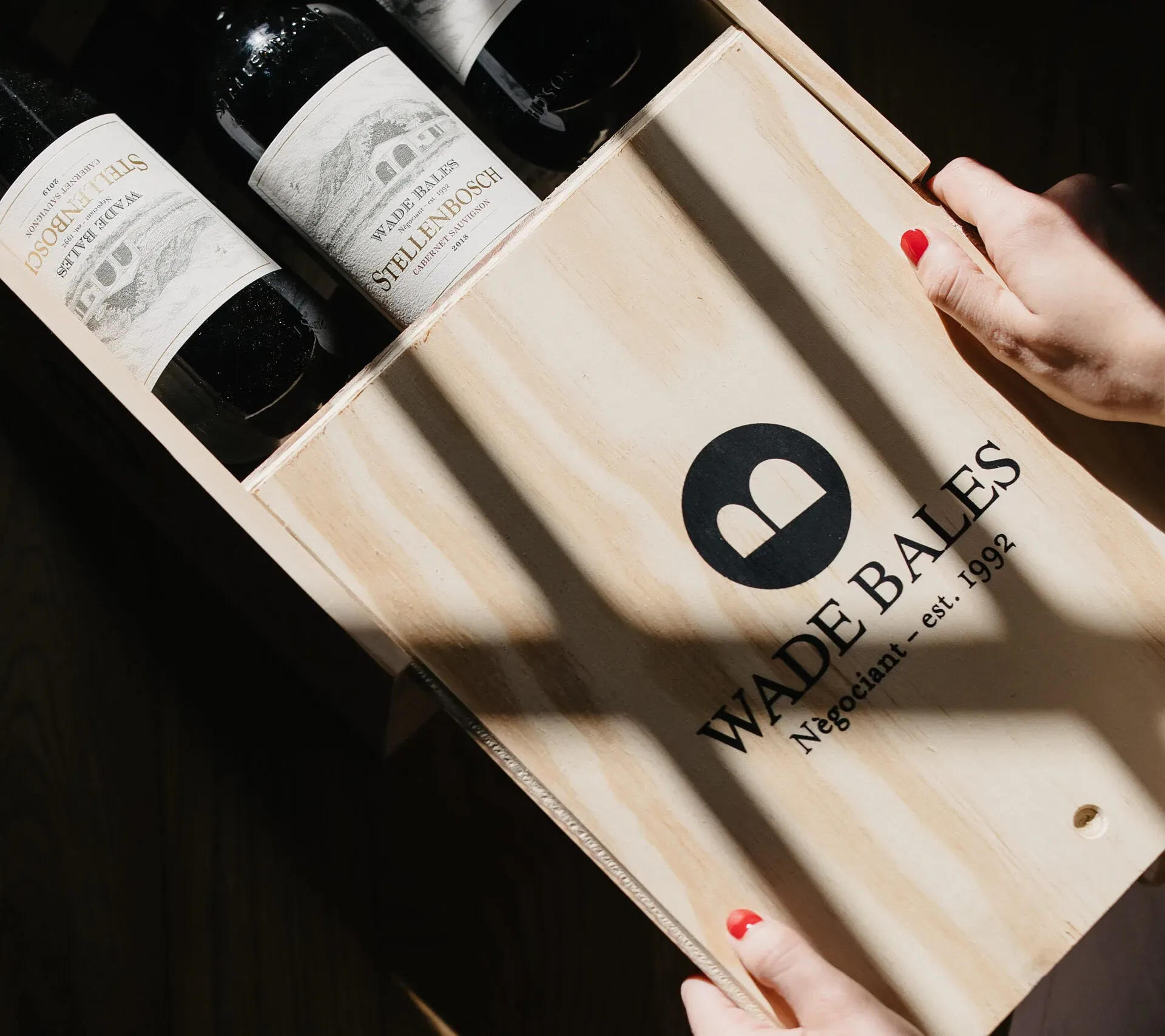 Hand Reaching For A Wooden Wine Box Containing Stellenbosch Cabernet Sauvignon.
