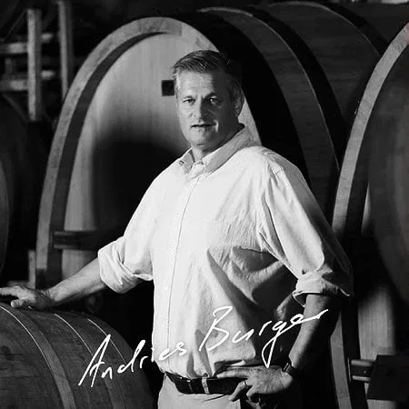 Andries Burger Standing Confidently Among Wine Barrels At Simon Wine Emporium.