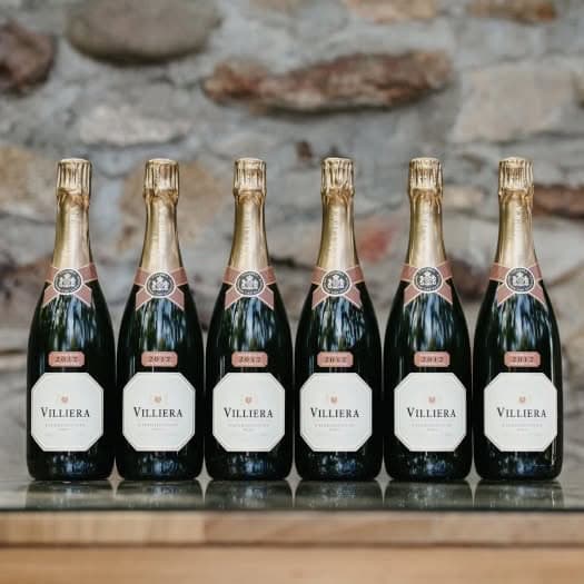 Six Bottles Of Villiera Brut Villiera Brut Natural 2021 Sparkling Wine Against A Stone Wall.